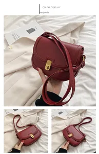 Detail view of wine red saddle bag with gold twist lock on smooth leather surface