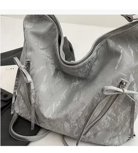 Macro shot of silver hobo bag with metallic pleated texture and side zipper detail