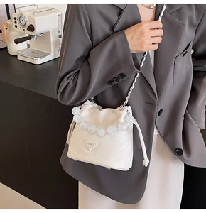 Détail du sac seau plissé blanc avec poignée en perles transparentes et chaîne