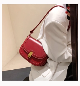 Detail of burgundy retro crossbody bag with a gold twist lock and fine stitching