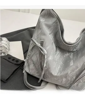 Close-up of silver pleated tote bag with bow detail and metallic texture for women