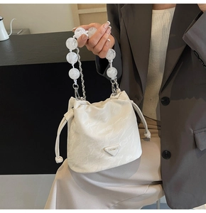 Détail du sac seau blanc à cordon avec texture marbre et chaîne en métal perlé