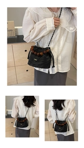 Détail du sac seau plissé noir avec poignée en perles ambrées et bandoulière