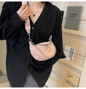 Detailed view of pink pleated half-moon crossbody bag with silver chain and wide strap