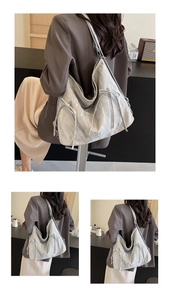 Detail view of silver pleated tote bag with bow accent and vertical zipper decorations