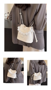 Détail du sac seau blanc à cordon avec poignée en perles transparentes et chaîne argentée