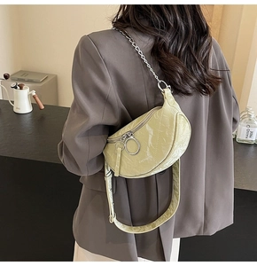 Detail of light green marble texture crossbody bag with silver ring zippers and chain strap