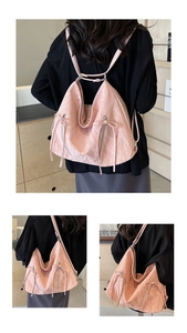 Detail of pink pleated tote showing metal zippers and decorative bow on shoulder bag