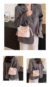 Détails du mini sac seau rose avec poignée en perles et logo triangulaire en métal