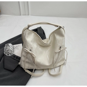 Detail of cream marbled leather backpack with dual zipper pockets and bow pulls