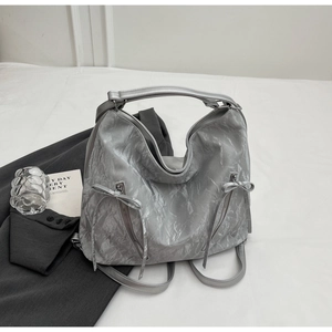 Close-up of silver textured tote bag featuring metallic folds and ribbon bow details