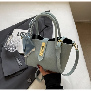 Close-up of light blue pebble leather tote bag with silk scarf and gold twist lock