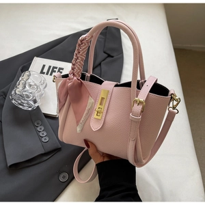 Detail of pink lychee leather bucket bag with silk scarf and gold twist lock closure