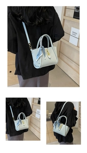 Detail of light blue lychee pattern bucket bag with decorative silk scarf and gold lock