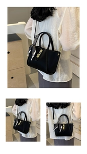 Detail of black pebbled leather bucket bag with gold hardware and striped fashion scarf
