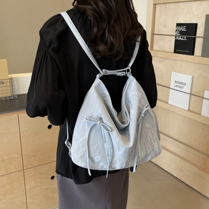 Light blue pleated oversized backpack with bow details and vertical zip pockets