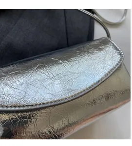 Close-up of silver crinkled texture fabric on cross-body bag with metallic finish