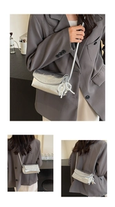 Close-up of metallic silver shoulder bag with pearl charm and pleated texture detail
