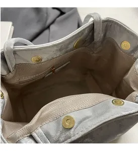 Vue détaillée de l'intérieur d'un sac argenté avec doublure chevron et fermoirs dorés