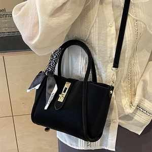 Chic black litchi pattern bucket bag with gold hardware and geometric silk scarf handle