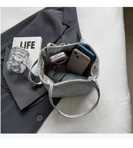 Sac seau argenté montrant l'intérieur spacieux pour téléphone et accessoires