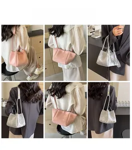 Détails des sacs à bandoulière en similicuir rose et argenté dans un café élégant