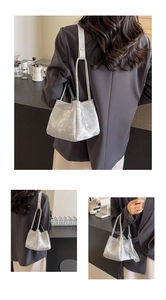 Détail du sac seau gris argenté avec texture marbre, fines poignées et bandoulière