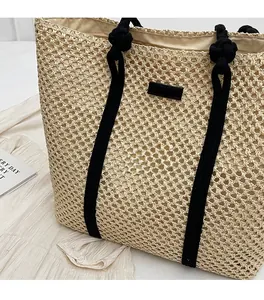 Détail du sac cabas en paille tissé main avec anse en corde noire et nœud décoratif