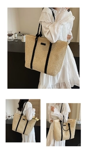 Détail d'un sac cabas en paille tissée beige avec anses noires dans un cadre cosy