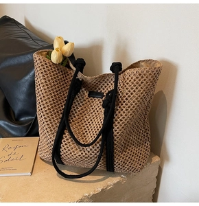 Vue détaillée du sac cabas en paille tissée avec anses en corde et écusson en cuir