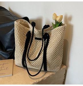 Gros plan détaillé de la texture en paille tressée avec des anses en corde noire du sac