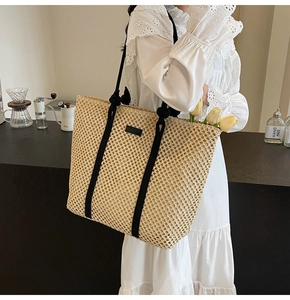 Détail du sac cabas en paille tissé à la main avec anses noires en corde pour l'été