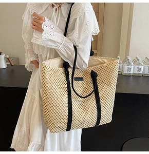 Détail d'un grand sac cabas en paille tressée avec poignées en corde pour les vacances