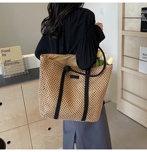 Gros plan sur un sac cabas en paille tissé à mailles ajourées avec anses en corde