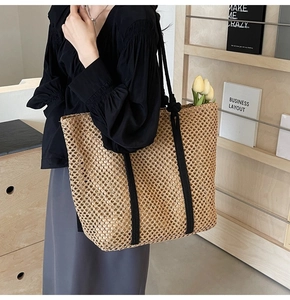Gros plan du sac fourre-tout en paille tissée à la main avec un design en maille évidée