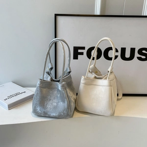Sacs seaux minimalistes en cuir argenté et blanc cassé avec de longues anses et plis