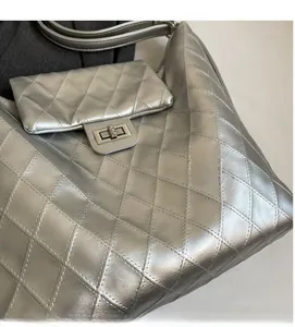Detail of silver quilted hobo bag featuring diamond stitching and metal twist lock