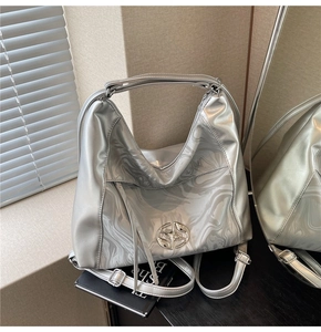 Borsa tote argento con trama marmorea fluida e logo in metallo in ambiente di design