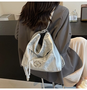 Dettaglio borsa tote argento metallizzato con logo stella e catena sulla spalla