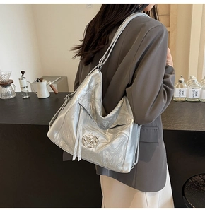 Dettaglio borsa tote argento metallizzato con texture marmorizzata e logo tondo