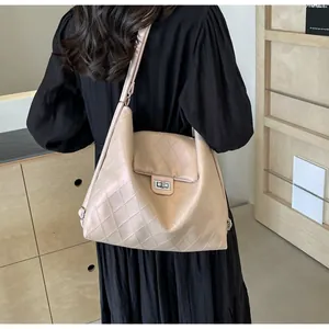 Detail view of light pink quilted tote bag with silver rotary lock shown on shoulder