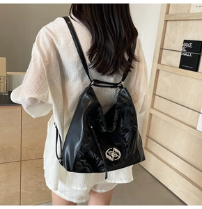 Macro della borsa tote in pelle verniciata nera lucida con fibbia circolare in argento
