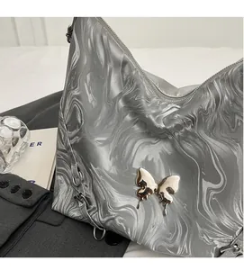Detail of silver marble texture fabric with Y2K metallic butterfly on the shoulder bag