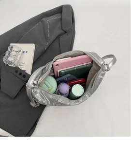 Detailed top view of silver metallic pleated backpack showing high capacity interior storage