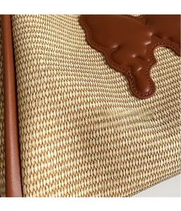 Close-up of woven straw texture and brown leather patch on a designer handbag