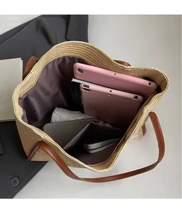 Spacious interior of beige woven tote bag holding tablets, phone, and an umbrella