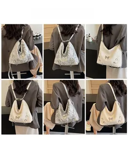 Detail showing versatile women's silver backpack with chic butterfly metal clasp and chain strap