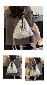 Detail of silver marble textured shoulder bag with metal butterfly and chain strap