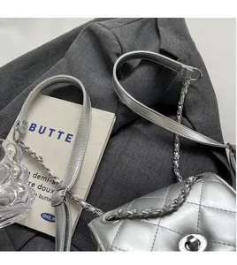 Close-up of silver quilted chain bag with metallic turn-lock and leather-chain strap