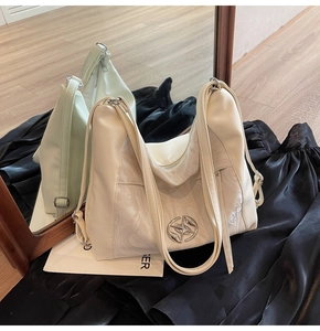 Dettaglio della borsa tote crema con inserto effetto marmo e fibbia metallica